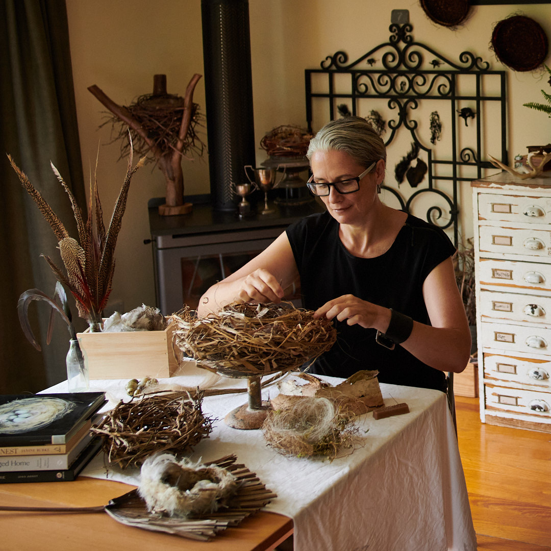 Zora Verona in her studio weaving and stitching nest sculptures